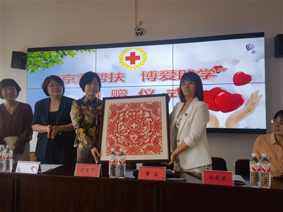 接受红十字志愿者赠送的剪纸画